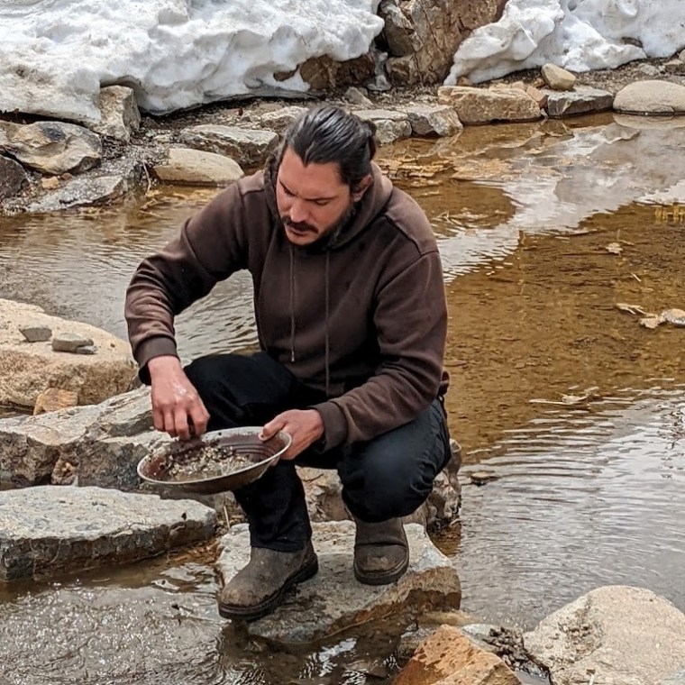 a man concentrating on panning for gold with country boy mine in breckenridge, colorado