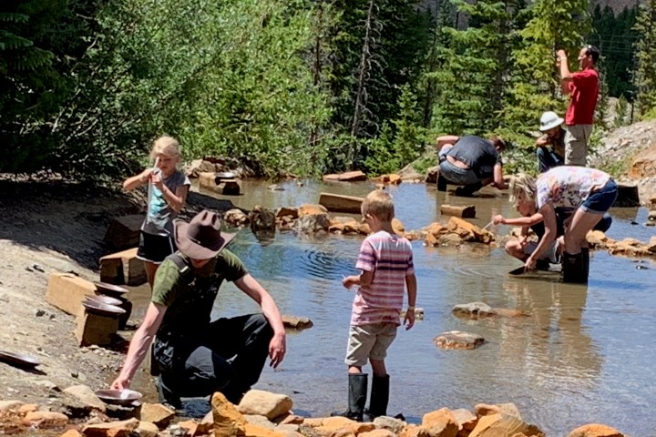 a group of people standing next to a river