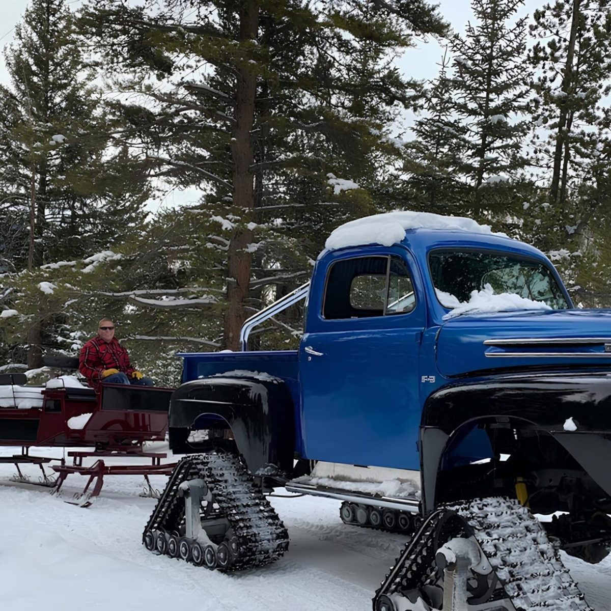 a man posing for the camera on a monster truck sleigh tour with country boy mine in breckenridge, colorado